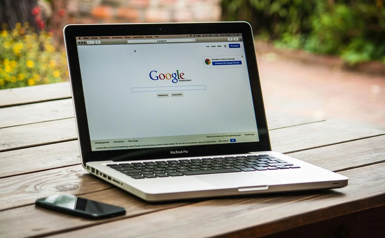 Laptop displaying Google on a wooden table.