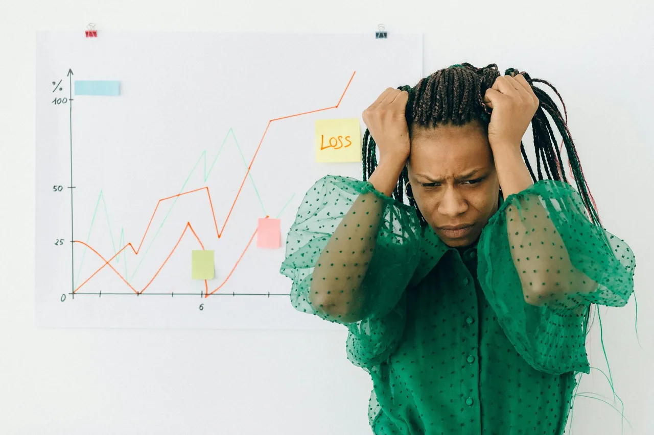 Person holding their head in front of a chart.